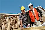 Surveyor and Construction Worker looking at building plan on construction Site