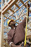 Construction worker measuring building