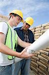 Two construction workers studying blueprints