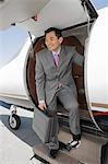 Asian businessman getting off airplane.