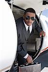 African-American businessman getting off airplane.