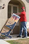 Delivery man holding cart with stack of containers