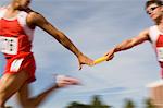 Athletes passing relay baton