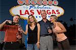 Deux femmes et deux hommes posant devant Bienvenue à Las Vegas sign