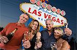 Deux femmes et deux hommes posant devant Bienvenue à Las Vegas sign, portrait de groupe.