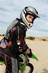 Motocross Racer on bike in desert, (portrait)