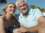Senior couple holding hands on tropical beach, close up
