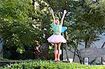 Girl wearing tutu and fairy wings playing in park