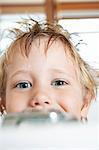 Boy with messy, wet hair, looking over edge of  Bathtub, close-up