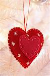 Heart shaped decoration hanging on Christmas tree, close-up