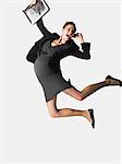 Pregnant Businesswoman on cell phone jumping, mid air