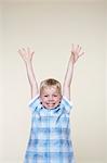 Smiling, excited boy standing with Arms Raised