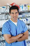 Male nurse standing by shelves with medical supply, portrait