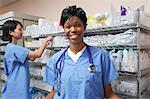 Portrait de femme médecin, infirmière, debout près d'étagères avec des fournitures médicales en arrière-plan