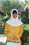 Portrait de jeune femme musulmane avec sac à provisions, souriant