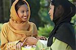 Zwei junge muslimische Frauen, die im freien sprechen