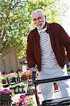 Elderly man with walking frame in garden center