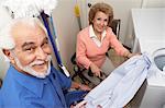 Couple with laundry by washing machine