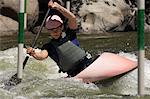 Young woman whitewater kayaking
