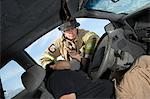 Firefighter looking into crashed car, view from interior