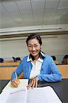 Mature female student working in lecture theatre, portrait