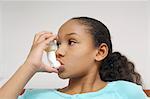 Girl (7-9) using inhaler in hospital