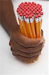 Person holding large group of pencils, close-up of hand