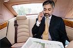 Homme d'affaires utilisant un téléphone cellulaire en voiture privée