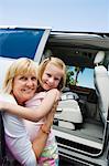 Mother Hugging Daughter by Minivan