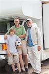 Father, son and grandson stand with RV home