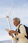 Mature woman with map by wind farm