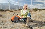 Leitende Frau mit Rucksack in der Nähe von Windparks