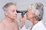 Senior medical practitioner examines man for sight test