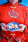 Woman holding plate of fortune cookies