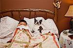 Boy in bed with Boston terrier