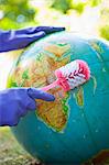 Woman wearing rubber gloves to scrub globe outdoors