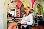 Beautician seated on chair in beauty salon