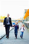 Father and children walking on pier