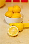 Bowl of lemons and lemon juicer on counter