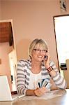 Femme à la maison bureau téléphone avec cartes de crédit