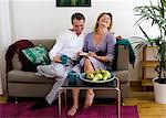 Mid adult couple laughing on sofa