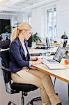 Businesswoman using laptop in office