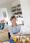 Portrait of mature woman eating breakfast at table