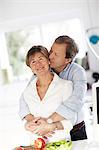 Portrait of mature couple embracing in kitchen