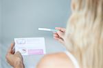 Woman reading pregnancy test, cropped