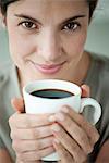 Mid-adult woman holding cup of coffee