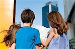 Children looking at map while sightseeing in city