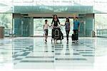 Familie drängen Gepäckwagen in Flughafen-lobby
