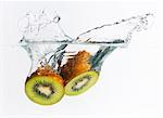 Kiwi halves splashing into water