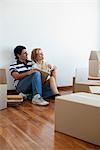 Couple unpacking cardboard boxes in new house